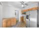 Kitchen area with refrigerator, microwave, and wood cabinets with a view to the dining area at 892 S Union Blvd, Lakewood, CO 80228