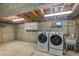 Basement laundry room featuring new washer and dryer, concrete floors, utility sink, and utility storage at 892 S Union Blvd, Lakewood, CO 80228