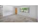 Empty living room with carpet, a door, and a window offering bright natural light at 892 S Union Blvd, Lakewood, CO 80228