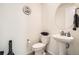 Stylish powder room featuring modern fixtures, a pedestal sink, and a round mirror at 13341 Olive St, Thornton, CO 80602