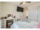 Cozy bedroom featuring a comfortable bed, a vanity area with a lighted mirror, and a ceiling fan at 13341 Olive St, Thornton, CO 80602