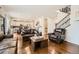 Open-concept living room showcasing hardwood floors, a staircase, and seamless transition to the kitchen at 13341 Olive St, Thornton, CO 80602