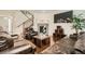 Cozy living room features hardwood flooring, a stone fireplace, and an adjacent staircase at 13341 Olive St, Thornton, CO 80602