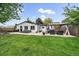 Expansive backyard featuring an entertainment space beneath a gazebo, plush green grass, and patio furniture at 2865 S Cherry Way, Denver, CO 80222
