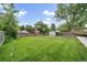 A spacious backyard featuring a lush lawn, wooden fence, mature trees, and a storage shed for outdoor equipment at 2865 S Cherry Way, Denver, CO 80222