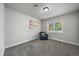 Cozy bedroom featuring plush carpet, a bright window, and comfortable blue armchair with colorful artwork at 2865 S Cherry Way, Denver, CO 80222