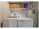 Functional laundry room with modern washer and dryer, storage shelves, and essential utilities at 2865 S Cherry Way, Denver, CO 80222