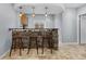 Stylish basement bar area with stone facade, pendant lighting, and seating for three, perfect for hosting at 3063 E 148Th Pl, Thornton, CO 80602
