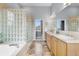 Bathroom featuring double sinks, a bathtub, and a glass block shower at 3063 E 148Th Pl, Thornton, CO 80602