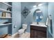 Stylish bathroom with a dark vanity, oval mirror, sconce lighting, and modern fixtures at 3063 E 148Th Pl, Thornton, CO 80602
