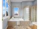 Bright bathroom with a large soaking tub and glass block shower at 3063 E 148Th Pl, Thornton, CO 80602