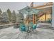 Outdoor patio with stone pavers, a seating area with an umbrella, and stairs leading to the upper deck at 3063 E 148Th Pl, Thornton, CO 80602