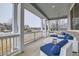 Inviting front porch featuring comfortable wicker seating with blue cushions and views of the neighborhood at 3063 E 148Th Pl, Thornton, CO 80602