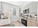 Sleek kitchen features stainless steel appliances, light wood cabinets, and herringbone backsplash at 5128 W 26Th Ave # 208, Denver, CO 80212