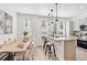 Bright kitchen showcases a center island with bar seating, modern pendants, and an adjacent dining area at 5128 W 26Th Ave # 208, Denver, CO 80212