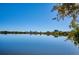 Scenic lake view with city skyline in the distance, framed by trees under a clear blue sky at 5128 W 26Th Ave # 208, Denver, CO 80212