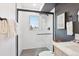 Shower features a herringbone tile pattern, black fixtures, and natural light from a window at 5128 W 26Th Ave # 208, Denver, CO 80212