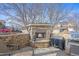 Backyard patio area with a stone outdoor fireplace, bbq grill, and seating at 8775 Wild Horse Way, Frederick, CO 80504