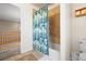 Bathroom with a shower featuring decorative tile and curtain next to a hallway entrance at 8775 Wild Horse Way, Frederick, CO 80504