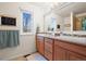 Bathroom features a double sink vanity, large mirror, and a bright window with natural light at 8775 Wild Horse Way, Frederick, CO 80504