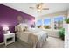 Cozy bedroom featuring a purple accent wall and a comfortable queen-sized bed with many pillows at 8775 Wild Horse Way, Frederick, CO 80504