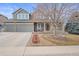 Two-story house with large driveway, stone accents, and a well-manicured landscaped front yard at 8775 Wild Horse Way, Frederick, CO 80504