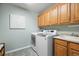 Clean and organized laundry room with modern appliances and ample cabinet space at 8775 Wild Horse Way, Frederick, CO 80504