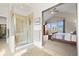 Luxurious bathroom featuring a glass-enclosed shower, tile flooring, and a view to bedroom at 8775 Wild Horse Way, Frederick, CO 80504