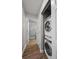 Hallway featuring stacked washer and dryer and full bathroom with tiled shower at 16120 E Radcliff Pl, Aurora, CO 80015
