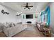 Spacious living room boasts a ceiling fan, comfortable seating, and a large flat-screen TV at 16120 E Radcliff Pl, Aurora, CO 80015