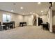 Recreational basement includes a dining table, foosball table, and stairway at 26554 E Indore Ave, Aurora, CO 80016