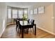 Bright dining room with a dark wood table, ample natural light, and contemporary wall art at 26554 E Indore Ave, Aurora, CO 80016