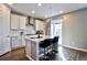 Bright kitchen featuring white cabinets, stainless steel hood, island seating, and sliding glass door at 26554 E Indore Ave, Aurora, CO 80016