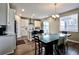 Well-lit kitchen with island seating, stainless steel appliances, and a dining area with large windows at 26554 E Indore Ave, Aurora, CO 80016