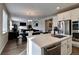 Open-concept kitchen with stainless steel appliances, a central island, and views into the living and dining areas at 26554 E Indore Ave, Aurora, CO 80016
