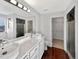 Bright bathroom with dual sinks, marble countertops, and wood-style flooring at 4548 Quandary Peak St, Brighton, CO 80601