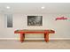 Basement game room with a shuffleboard table, a large piece of art, and a view to the outside at 3807 S Jasmine St, Denver, CO 80237