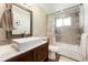 Bathroom features a large square sink, stained cabinets, and a shower with decorative tiling at 3807 S Jasmine St, Denver, CO 80237