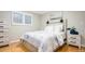 Cozy bedroom with a white headboard, matching side table and dresser, and a bright window at 3807 S Jasmine St, Denver, CO 80237