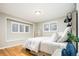 Bright bedroom features wood floors, white trim, natural light, and a modern bed and side table at 3807 S Jasmine St, Denver, CO 80237