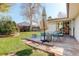 Landscaped backyard featuring a wooden deck with patio seating, a small privacy fence, and green grass at 6071 S Ingalls St, Littleton, CO 80123