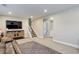 Open basement featuring a TV, stairway, and an adjacent bathroom with white fixtures at 6071 S Ingalls St, Littleton, CO 80123
