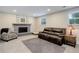 Cozy basement with brick fireplace, comfortable sofa, and ample natural light from a window at 6071 S Ingalls St, Littleton, CO 80123