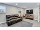 Spacious basement featuring a comfortable sofa, television, and ample natural light from a window at 6071 S Ingalls St, Littleton, CO 80123