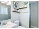 Clean bathroom with modern fixtures, a large mirror, open shelving, and a tiled shower at 6071 S Ingalls St, Littleton, CO 80123