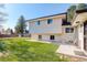 Back exterior showcasing a large lawn, patio, siding, and access to the upper levels at 6071 S Ingalls St, Littleton, CO 80123
