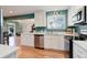 Bright, updated kitchen features modern appliances, white cabinets, and seamless flow to other living areas at 6071 S Ingalls St, Littleton, CO 80123