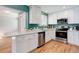 Updated kitchen boasts stainless steel appliances, white cabinetry, and ample counter space at 6071 S Ingalls St, Littleton, CO 80123