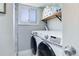 Laundry room featuring a modern washer and dryer set, window, and shelving for storage at 6071 S Ingalls St, Littleton, CO 80123