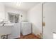 Laundry room with a sink, washer, dryer, wood floor, and access door at 3280 Ames St, Wheat Ridge, CO 80212